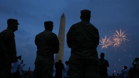 People watch as fireworks explode near the Washington Monument following the US Army's 250th celebration on Saturday, June 14, in Washington, DC.