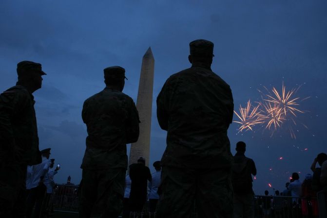 People watch as fireworks explode near the Washington Monument following the US Army's 250th celebration on Saturday, June 14, in Washington, DC.