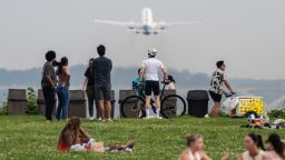 A vendor sells ice cream as people watch a plane take off at Gravely Point during a severe heat wave in Arlington, Virginia on June 22. 