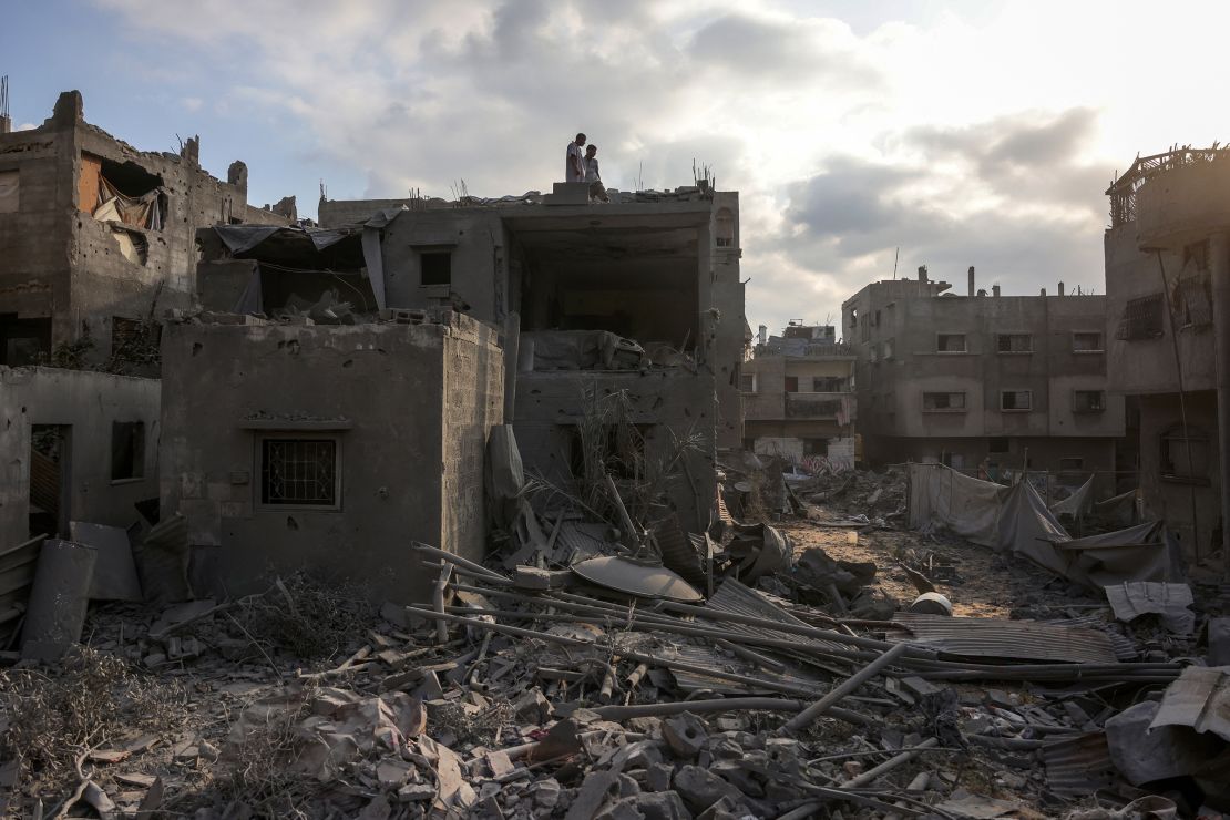 Palestinians standing atop a building look at the rubble of the Abu Nadi home which was hit in an Israeli strike west of Jabalia in the northern Gaza Strip on June 23.