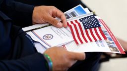 A new US citizen holds a program before receiving their naturalization certificates during a formal ceremony at Midway International Airport in Chicago, on June 25.
