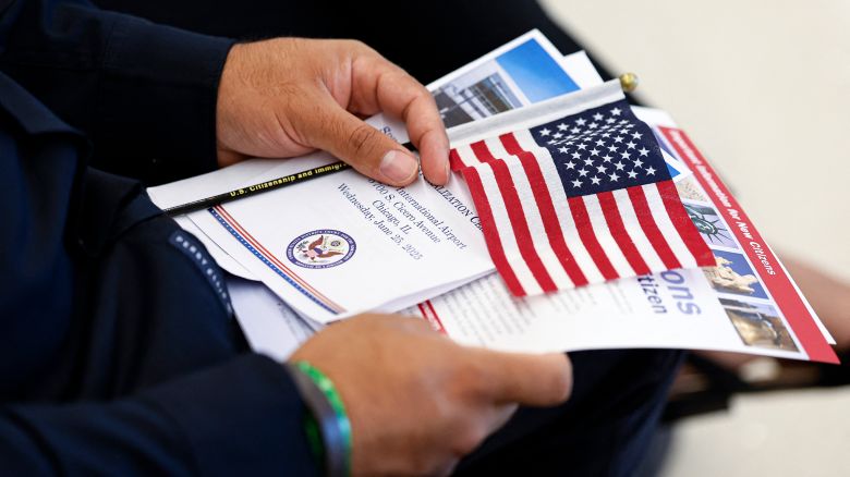 A new US citizen holds a program before receiving their naturalization certificates during a formal ceremony at Midway International Airport in Chicago, on June 25.