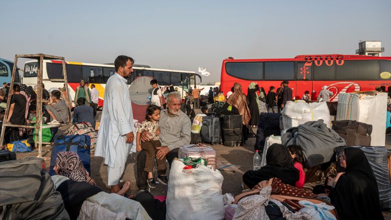 Afghans wait for shuttles and assistance at the overcrowded border reception area in Islam Qala, Afghanistan, near the Afghanistan-Iran border, on July 3.