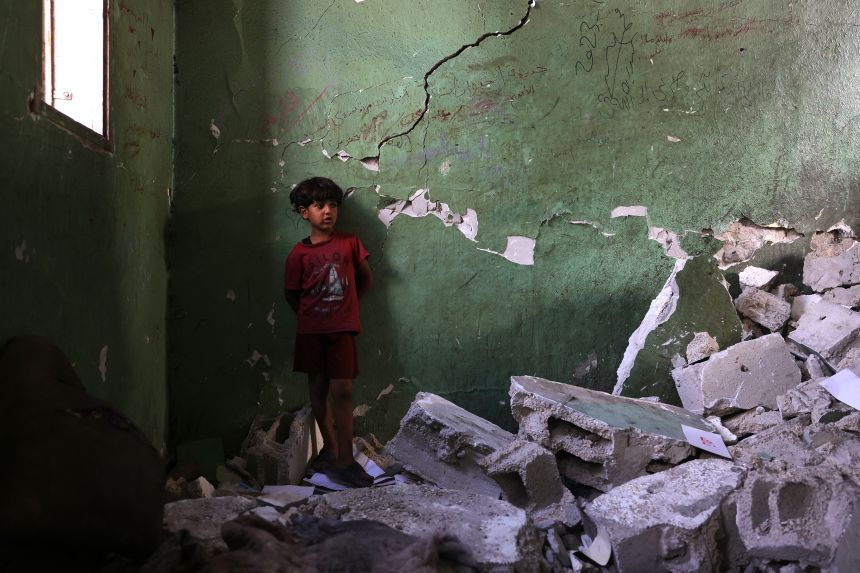 A Palestinian boy inspects the damage at the site of an overnight Israeli strike on the Halima Saadiya school in Jabalia in the northern Gaza Strip on July 11.