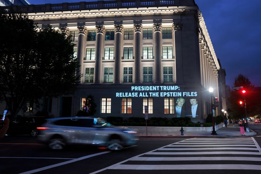 An image of President Donald Trump and Jeffrey Epstein, along with the words “President Trump: Release All the Epstein Files”, is projected onto the US Department of Commerce headquarters on July 18, in Washington, D.C.