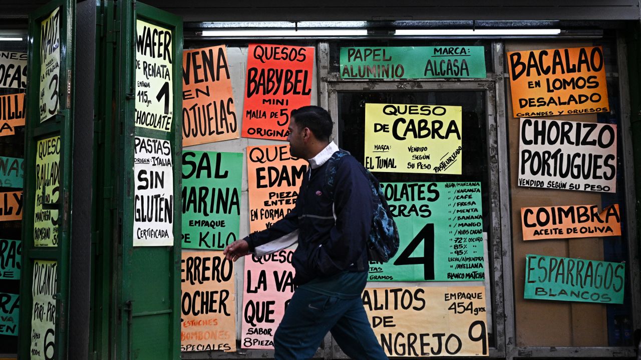 A man walks past signs displaying prices of products in US dollars at a supermarket in Caracas on September 30, 2025.