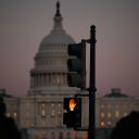 A crosswalk signal of a traffic light flashes backdropped by the US Capitol in Washington, DC, on October 1, 2025, the first day of the US federal government shutdown.
