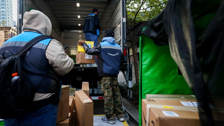 Workers unload Amazon packages from a Prime delivery truck in New York on October 28, 2025.