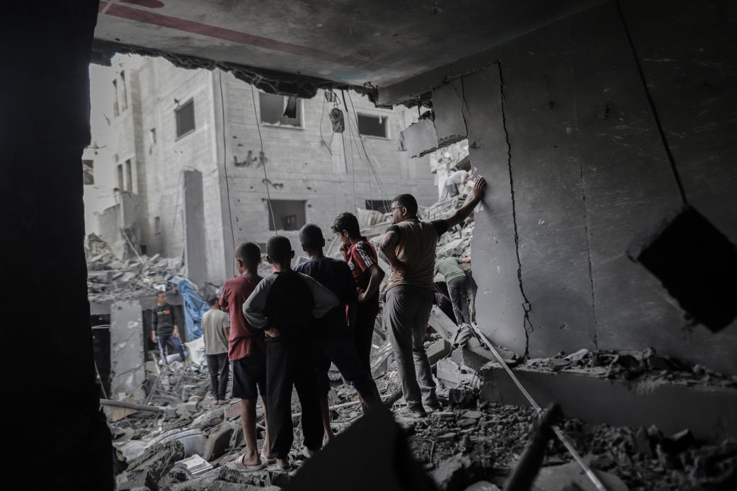 Palestinians look out from a damaged building following an Israeli airstrike at the Al-Shati refugee camp in Gaza City, northern Gaza, on Wednesday,