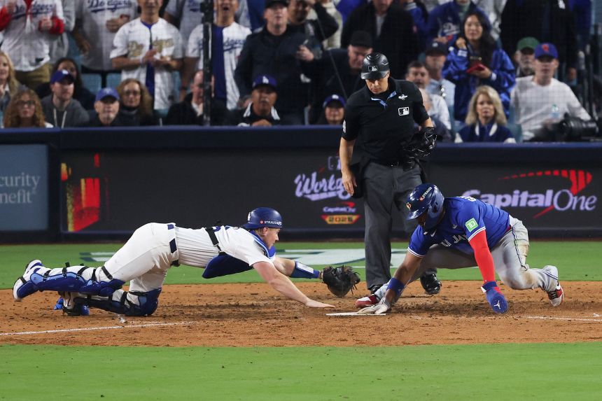 Vladimir Guerrero Jr. of the Toronto Blue Jays narrowly beats the tag by Los Angeles Dodgers Will Smith.