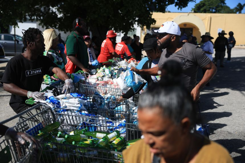 People receive groceries from a food bank in Miami on October 30.