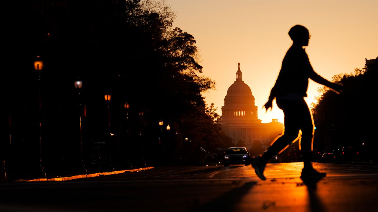 A pedestrian walks along Pennsylvania Avenue near the U.S. Capitol during sunrise on November 5, 2025 in Washington, DC.