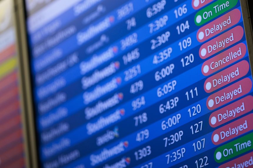 The departures board showing delayed flights at Orlando International Airport on Sunday