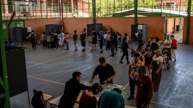 Voters wait in line to cast ballots at a polling station during the presidential election in Santiago, Chile, on Sunday.