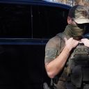 A Department of Homeland Security Investigations Officer searches for two individuals who fled the scene after being stopped while selling flowers on the side of the road on November 16, 2025 in Charlotte, North Carolina.