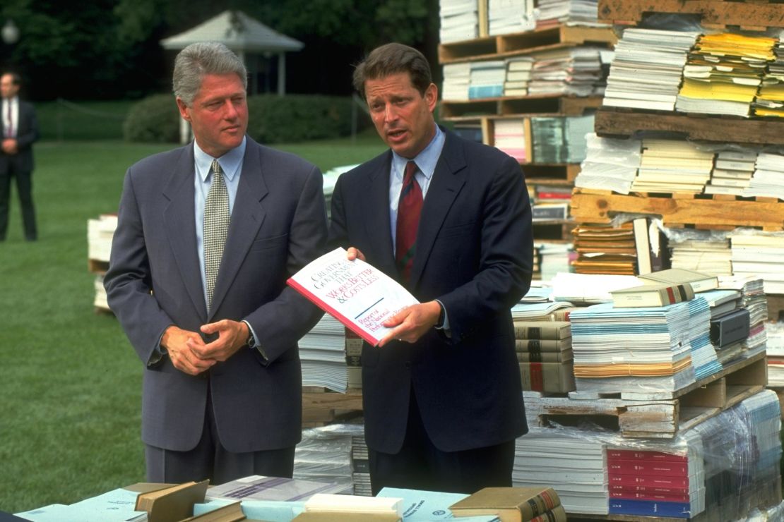 In this September 7, 1993 photo, President Bill Clinton and Vice President Al Gore present a report on increasing government efficiency as part of Clinton's charge of "reinventing government." Surrounding Clinton and Gore are piles of government regulation books outside of the White House in Washington, DC. 