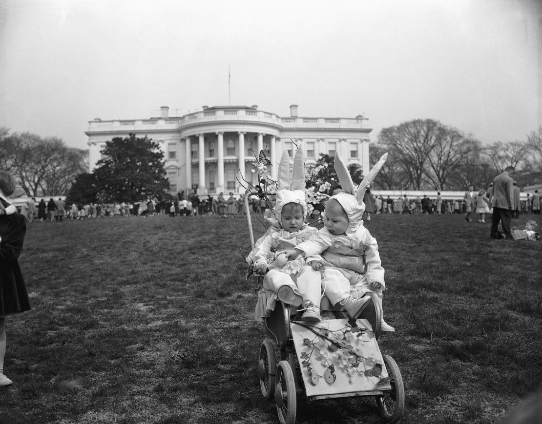 Two kids dressed up as bunnies enjoy the annual tradition in April 1956.