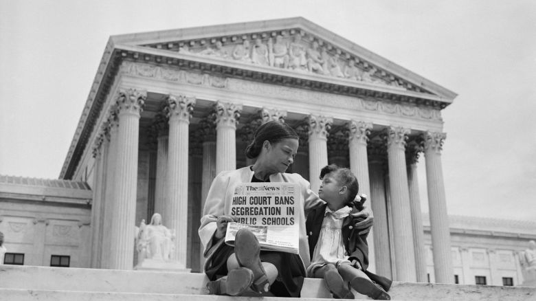 Nettie Hunt and her daughter Nickie sit on the steps of the U.S. Supreme Court. Nettie explains to her daughter the meaning of the high court's ruling in the Brown Vs. Board of Education case that segregation in public schools is unconstitutional. (Photo by UPI/Bettmann via Getty Images)