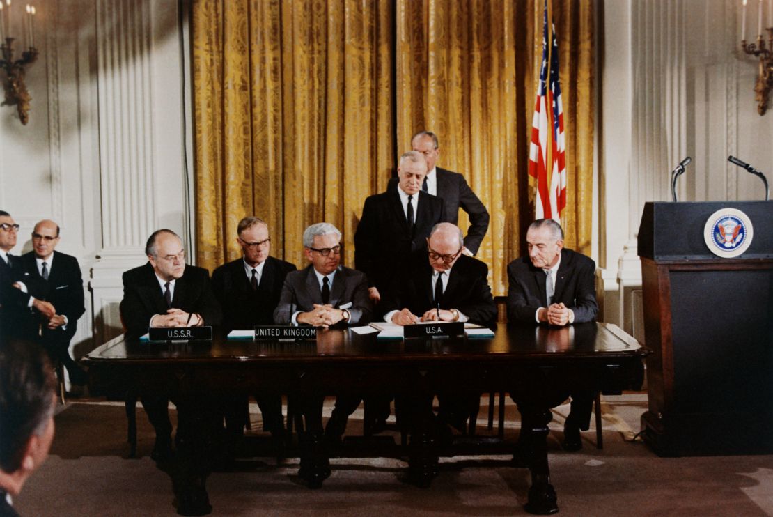 President Lyndon B. Johnson, right, watches as other nations, including the Soviet Union, signs an international treaty banning weapons in outer space on January 27, 1967, in Washington, DC.