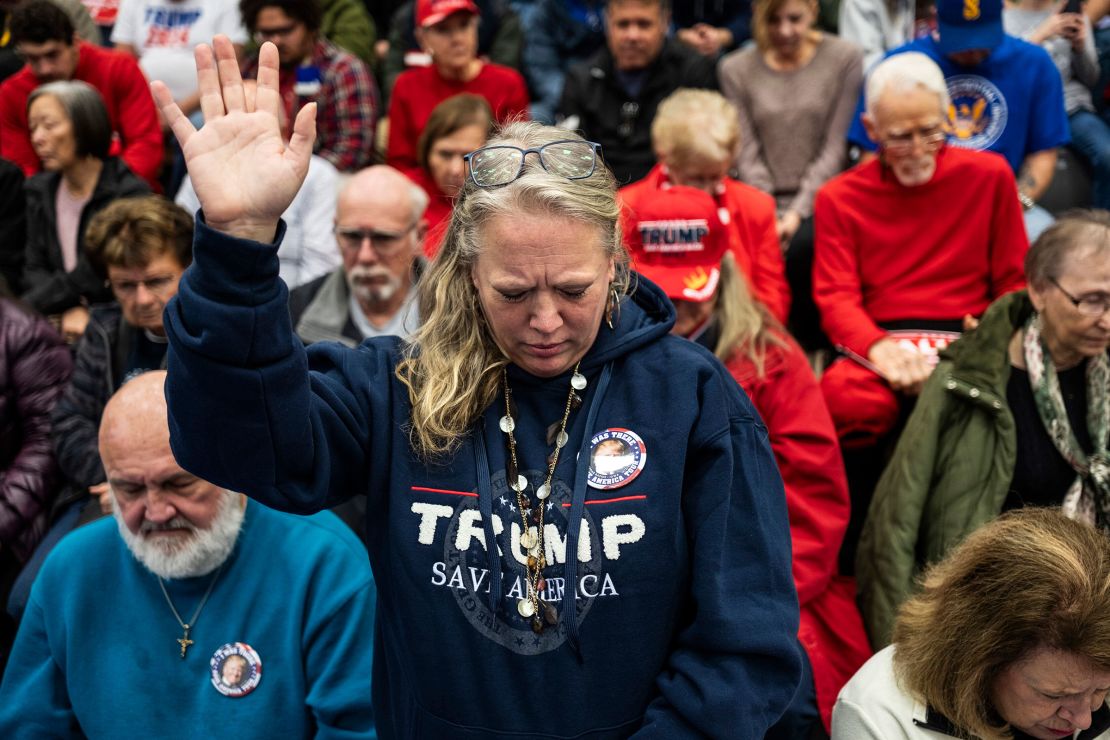 Para peserta berdoa selama acara Commit to Caucus yang diadakan oleh kampanye mantan Presiden Donald Trump di Cedar Rapids, Iowa, pada bulan Desember 2023.