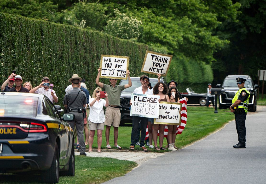 People hold signs calling for President Joe Biden to step aside this upcoming election in East Hampton, New York, as Biden's motorcade passes by on Saturday, June 29, 2024.