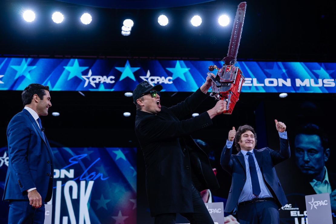 Elon Musk on stage with a chainsaw gifted to him by President Javier Milei of Argentina, right, during the 2025 Conservative Political Action Conference in National Harbor, Maryland, on February 20.