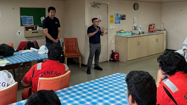 Bro Chen Chuanyi, executive secretary of the Singapore Organisation of Seamen, left, and Gwee Guo Duan, assistant general secretary of the Singapore Maritime Officers’ Union, right, speak with crew members aboard the Dali cargo ship on April 24, 2024.