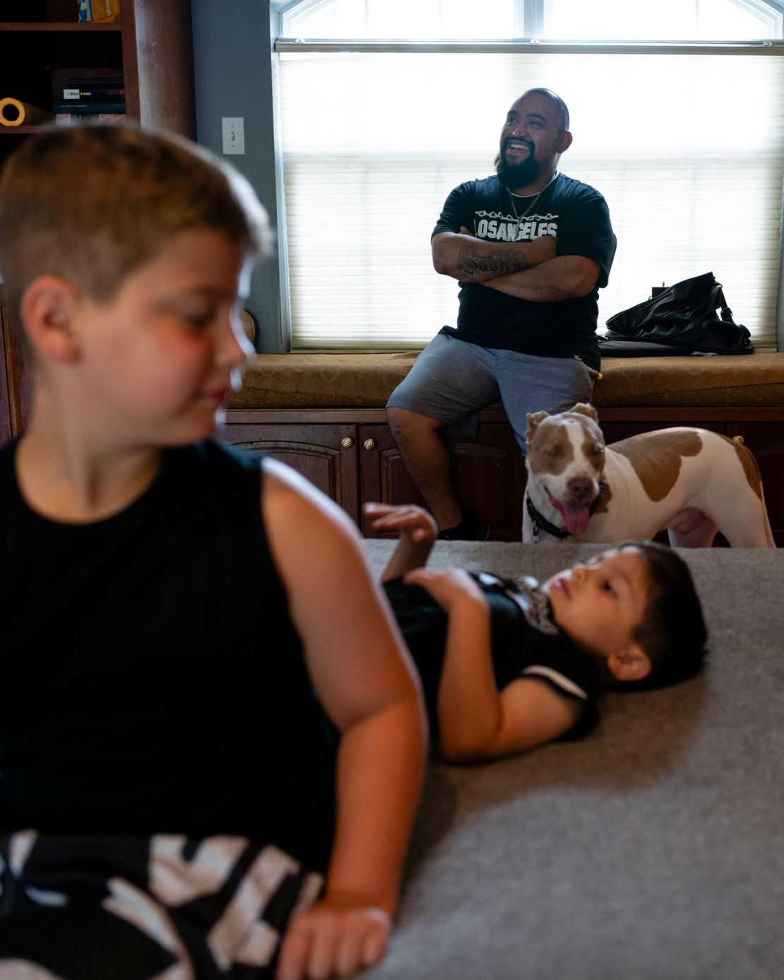Julio sits with his sons Graycen and Junior before the going-away party.