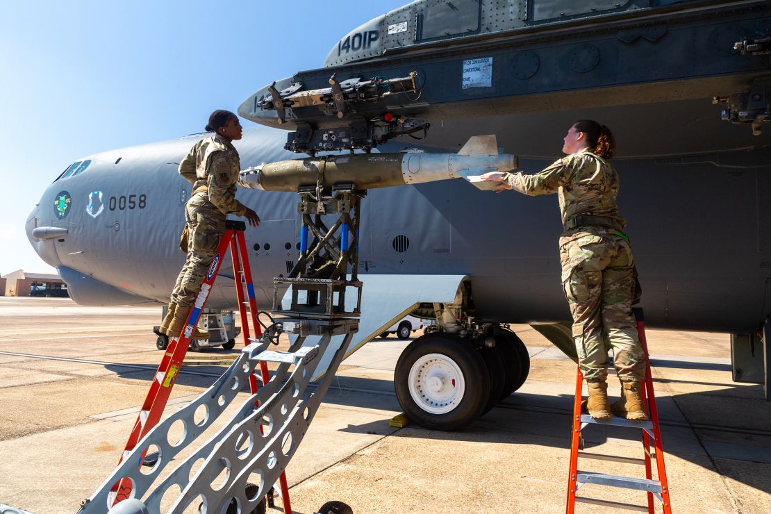 Staff Sgt. Dakeeja Nelson, left, and Senior Airman Veruca Plott, right, check that a precision 500 pound bomb has been properly loaded on the underwing bomb rack of a B-52H.