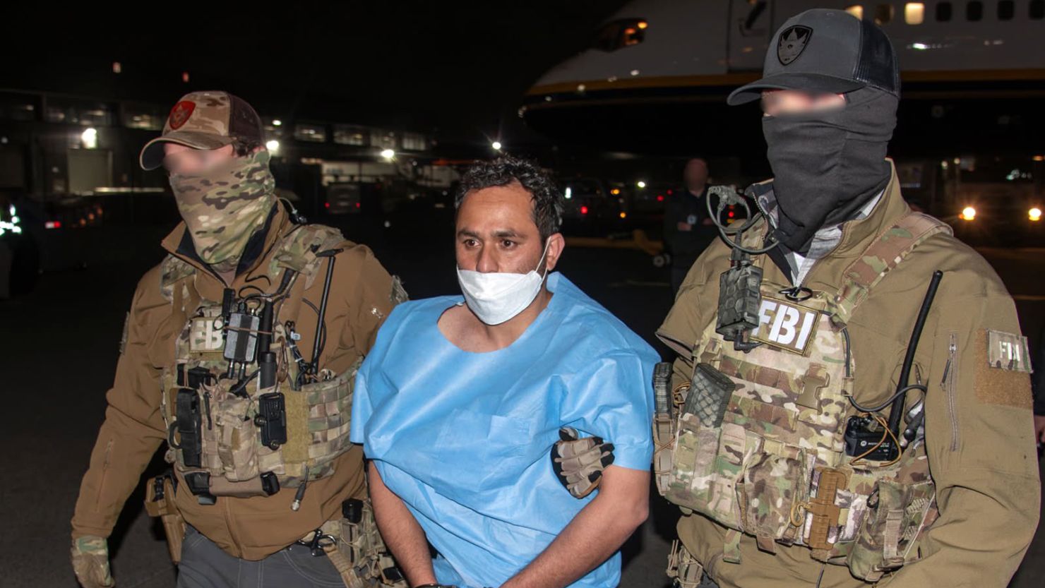 This photo posted to the social media platform X on March 5 by FBI Director Kash Patel shows Mohammad Sharifullah being escorted from a plane by two FBI officers. Editor's note: Portions of the faces of the FBI officers have been obscured by the FBI. 