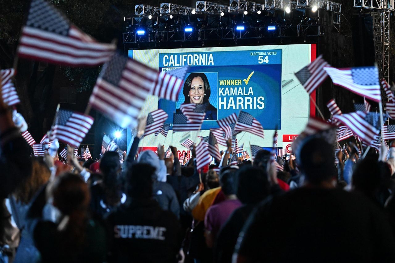 People wave American flags after CNN projected that Vice President Kamala Harris won California at Howard University in Washington, DC, on Tuesday, November 5.