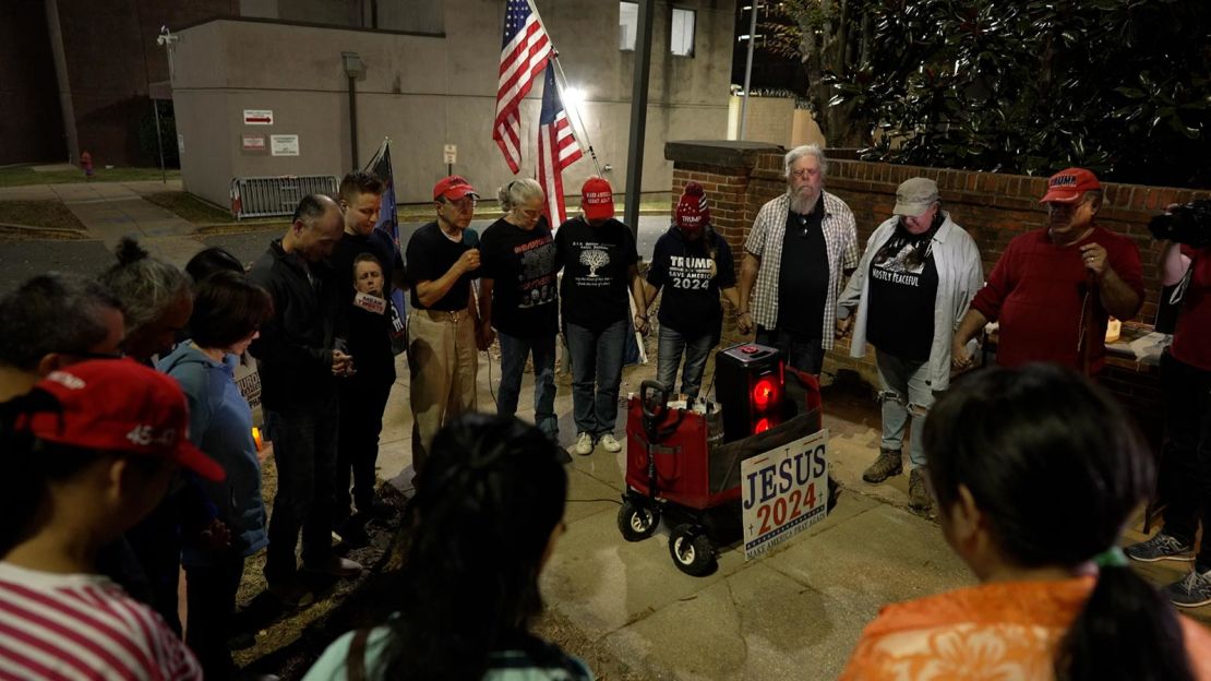 A pastor leads the group in prayer to begin their nightly ritual.