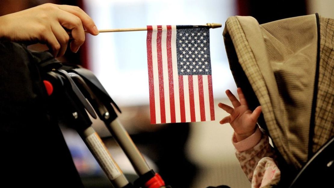 En esta foto de 2011, un bebé alcanza una bandera estadounidense durante una ceremonia de naturalización en Nueva York.