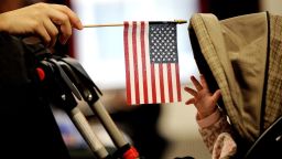 En esta foto de 2011, un bebé alcanza una bandera estadounidense durante una ceremonia de naturalización en Nueva York.