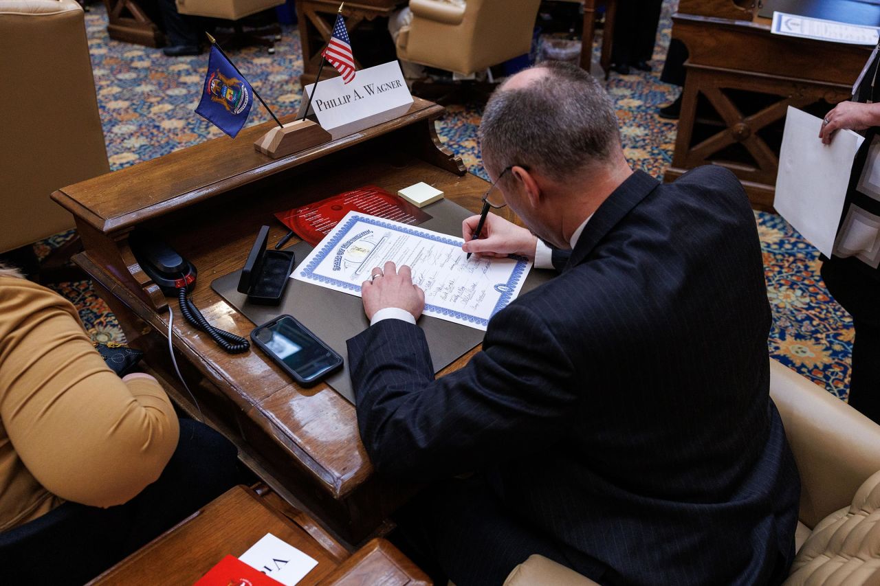 Phillip Wagner signs one of 100 certificates of votes for president and vice president during a meeting of Michigan's presidential electors in Lansing, Michigan, on December 17. 