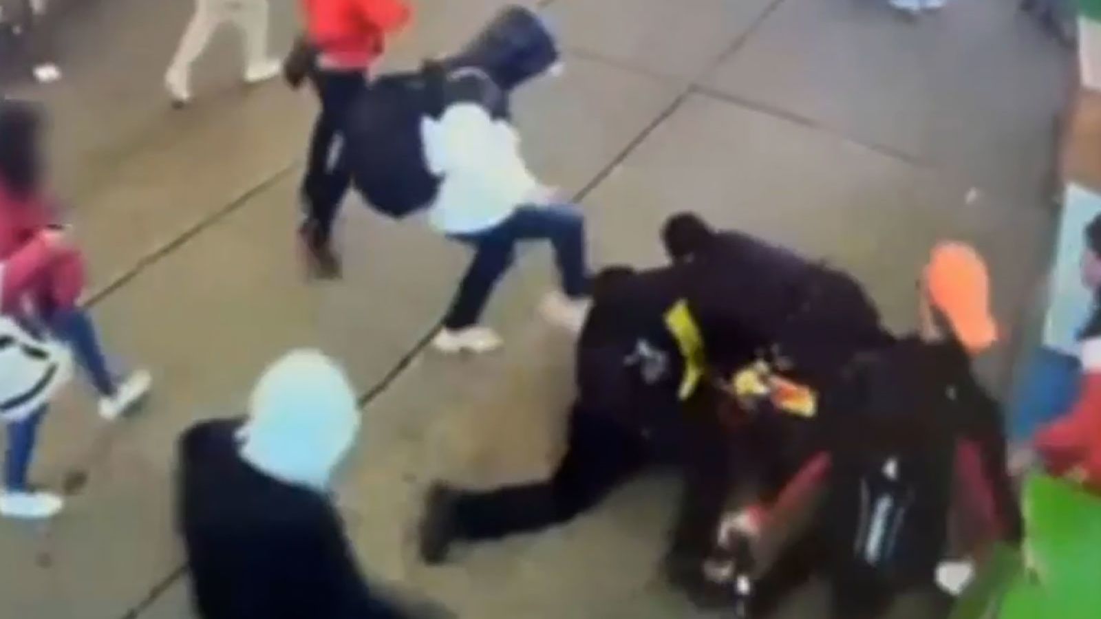 This screengrab from video from the New York Police Department shows a group of migrants assaulting two New York Police Department officers, with one officer on the ground repeatedly kicked and punched by the group of men after the officers attempted to break up a disorderly group near Times Square in the Saturday incident.