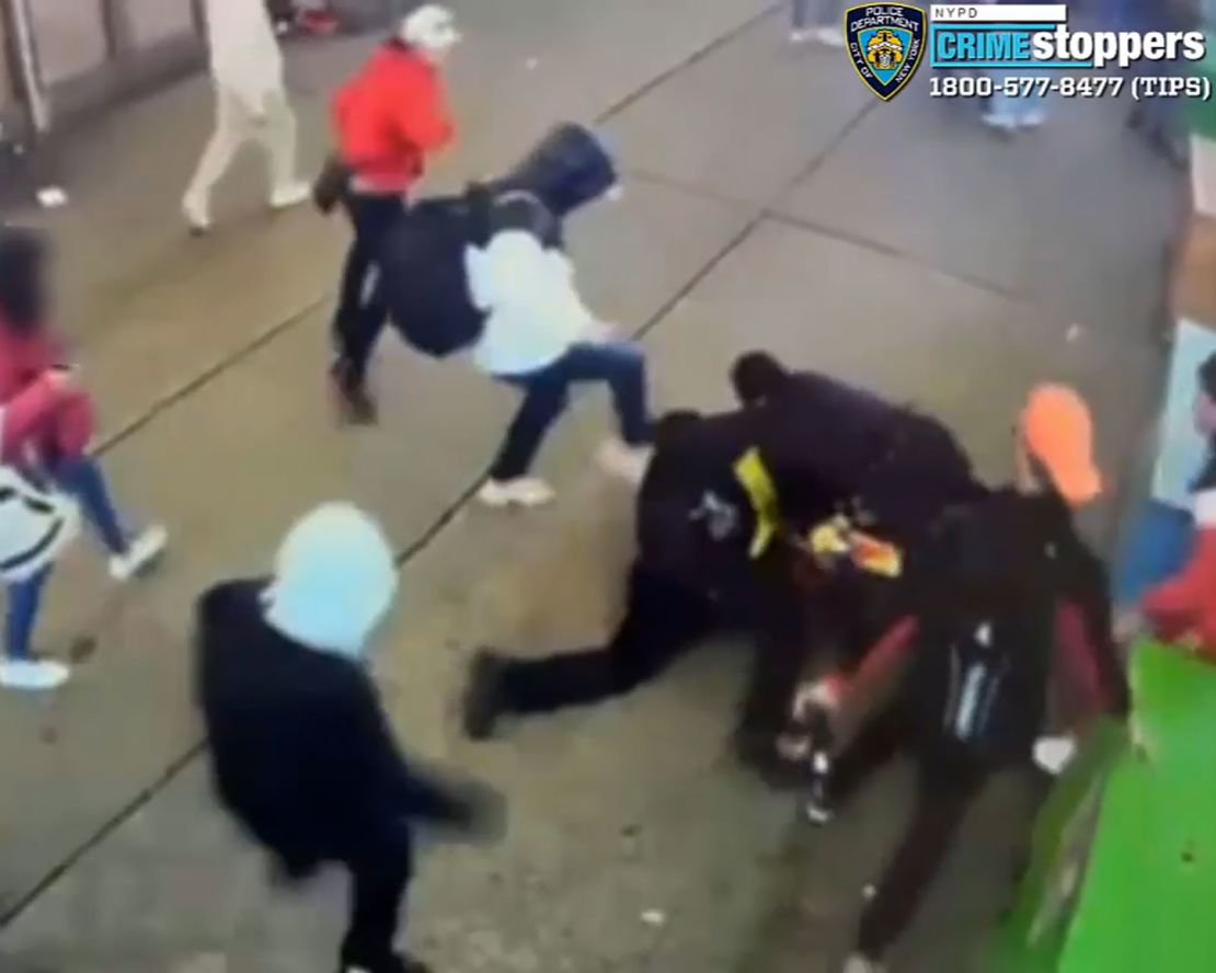 This screengrab from video from the New York Police Department shows a group of migrants assaulting two New York Police Department officers, with one officer on the ground repeatedly kicked and punched by the group of men after the officers attempted to break up a disorderly group near Times Square in the Saturday incident.