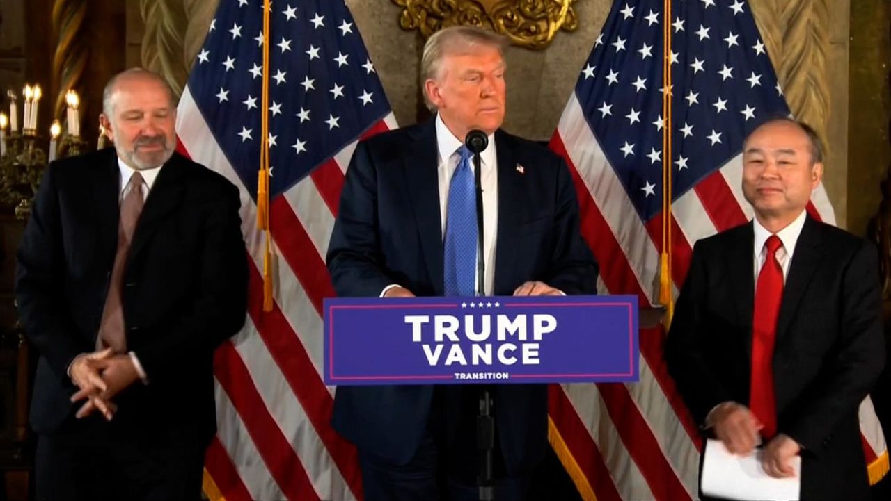 President-elect Donald Trump stands with Howard Lutnick, left, and SoftBank CEO Masayoshi Son, right, at Mar-a-Lago in Palm Beach, Florida, on Monday, December 16. 