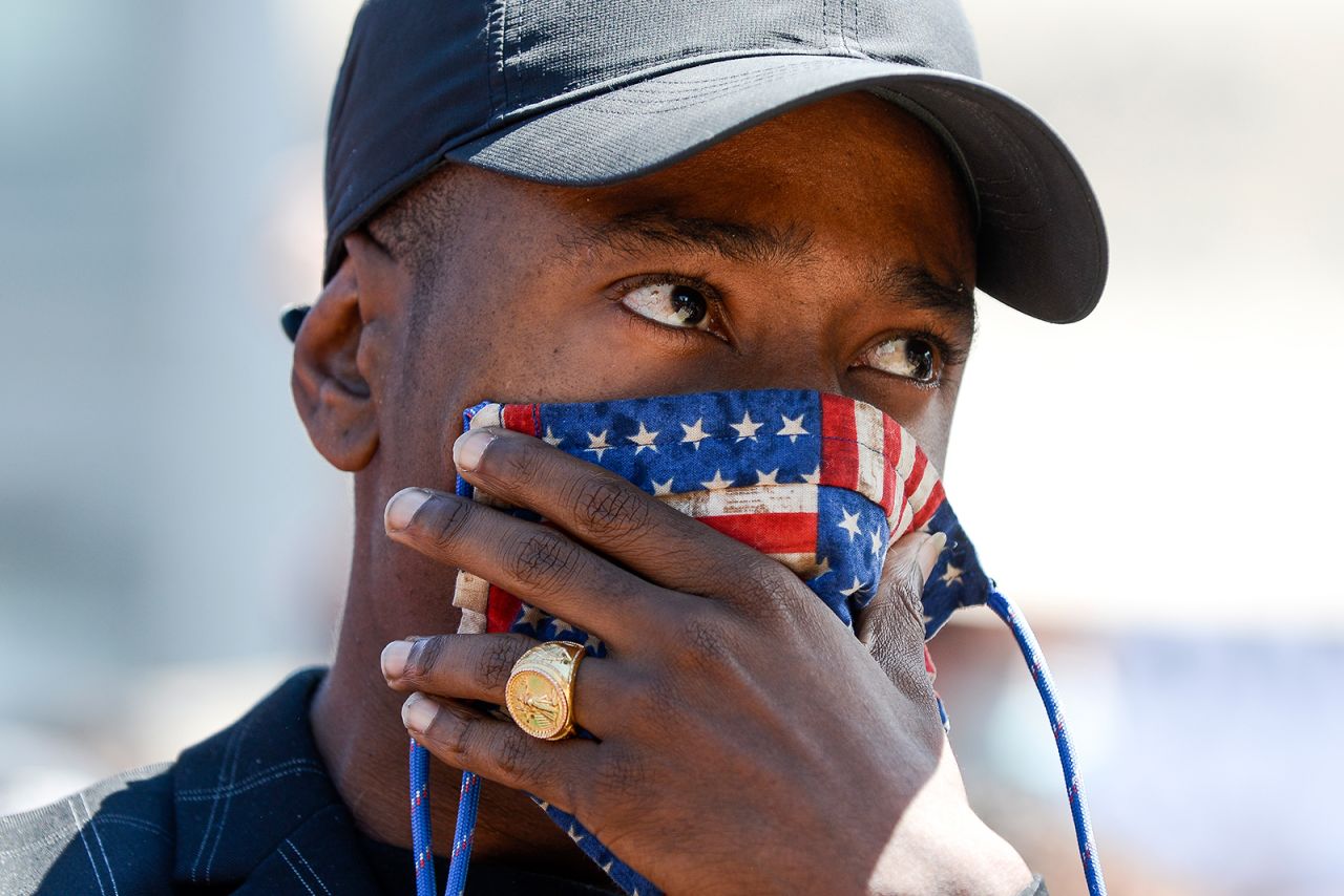 A man holds a mask over his face as thousands of people rally next to the Colorado State Capitol to protest the death of George Floyd on May 30, in Denver, Colorado. 