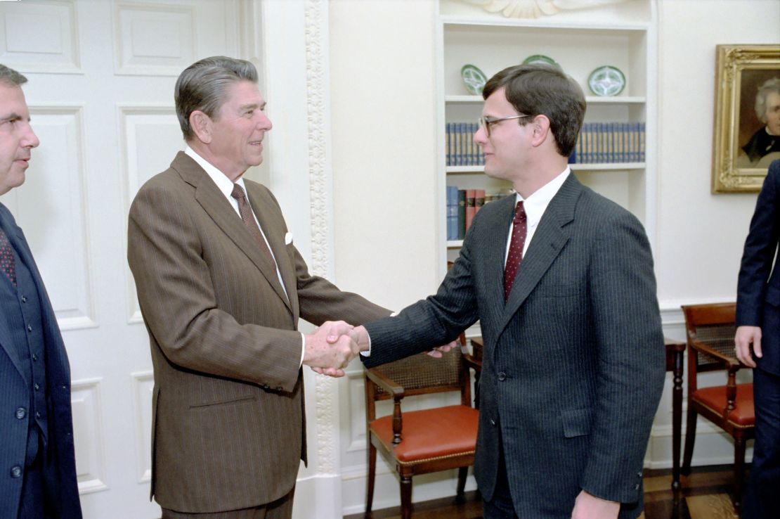 In this January 1983 photo, President Ronald Reagan greets John Roberts during a photo opportunity with members of the White House Counsel's Office in the Oval Office in Washington, DC.