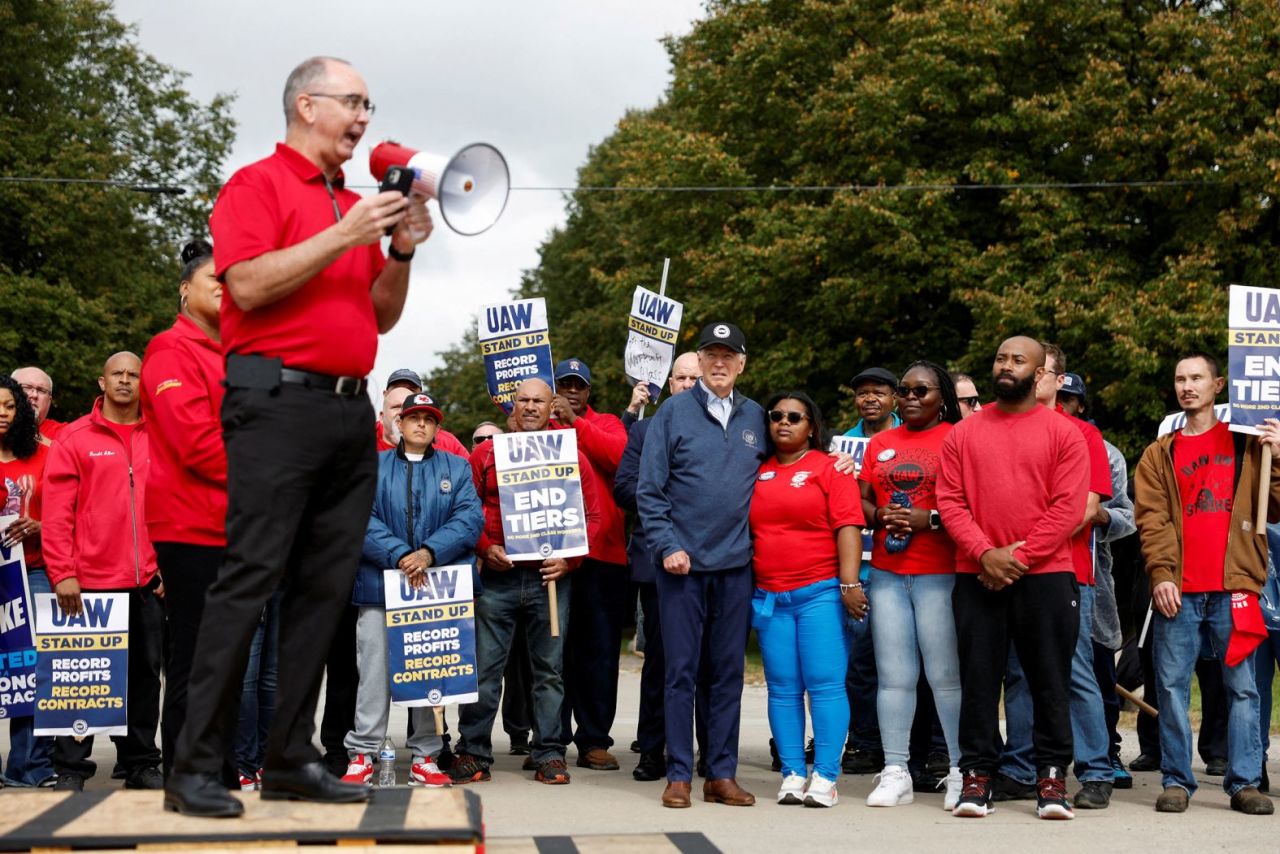 Shawn Fain, president of the United Auto Workers, speaks as Biden, center, joins?striking union members?on the picket line in Belleville, Michigan, in September 2023. Biden made history by being the first sitting president to join a picket line.?