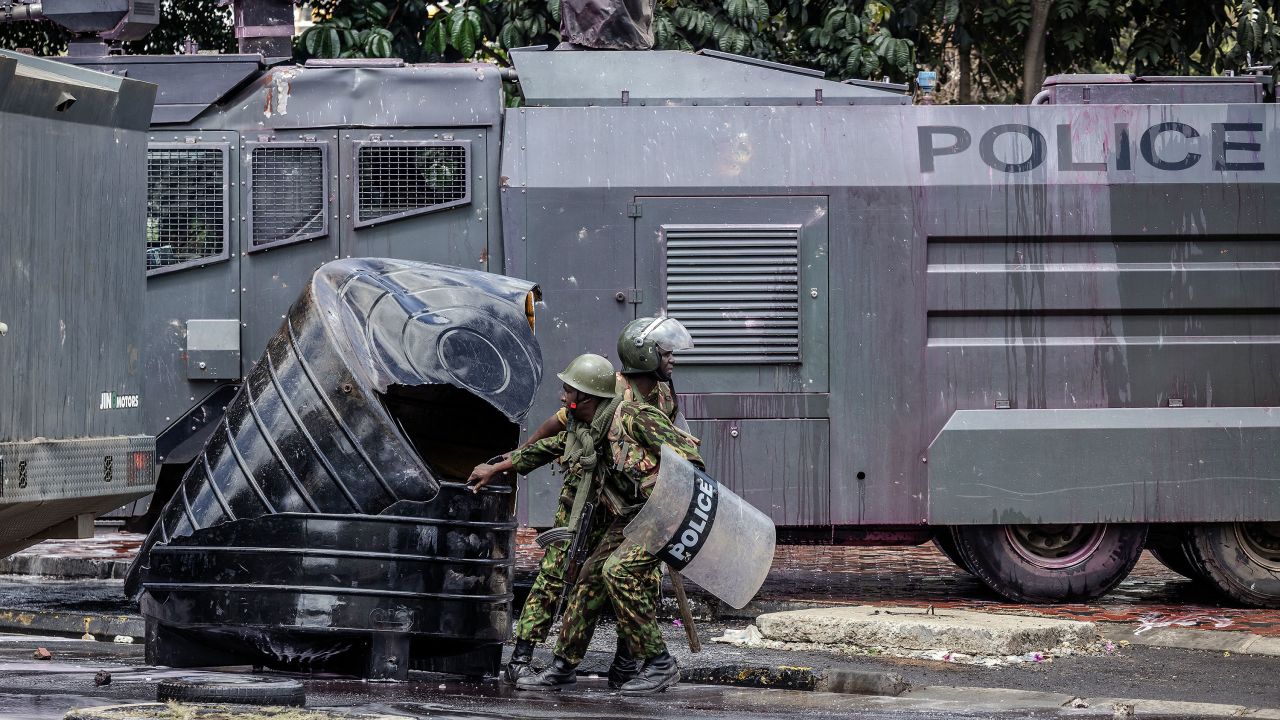 Police officers remove barricades from a road as they clash with protesters in downtown Nairobi on Tuesday.