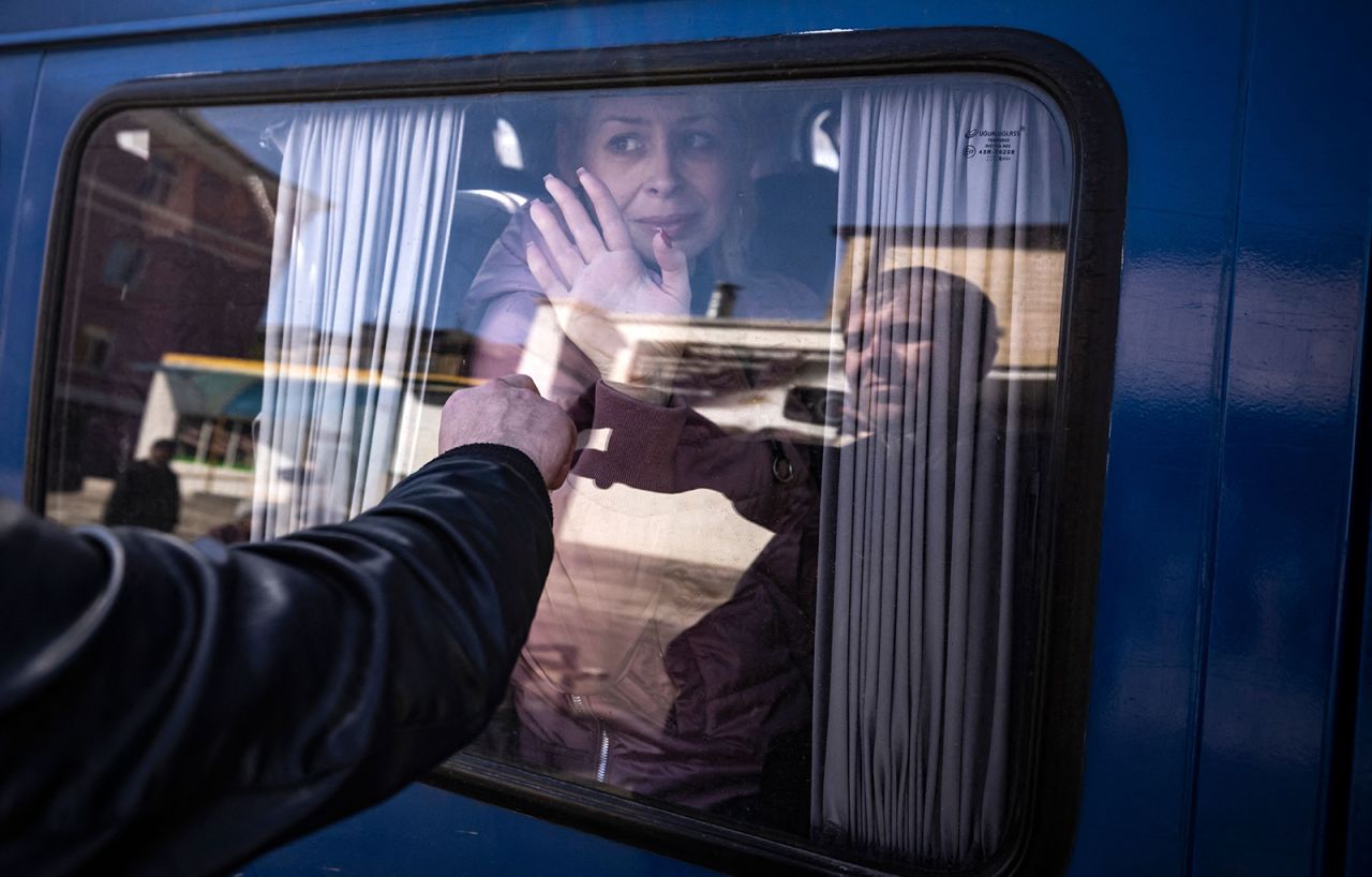 A woman waves to say good bye to her husband as she leaves on a bus in Kramatorsk, Ukraine on April 9.