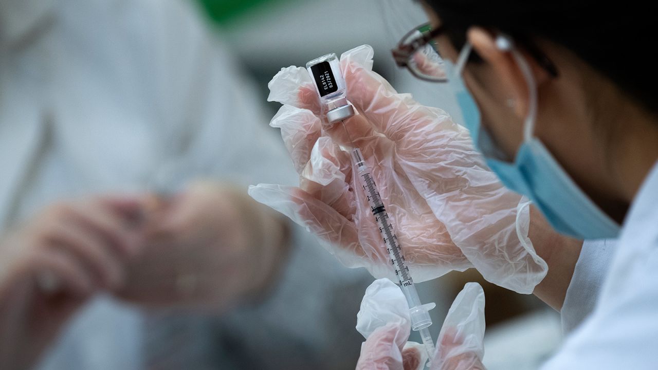 A pharmacist dilutes the Pfizer Covid-19 vaccine while preparing it to administer to staff and residents at the Goodwin House Bailey's Crossroads, a senior living community in Falls Church, Virginia, on December 30. 