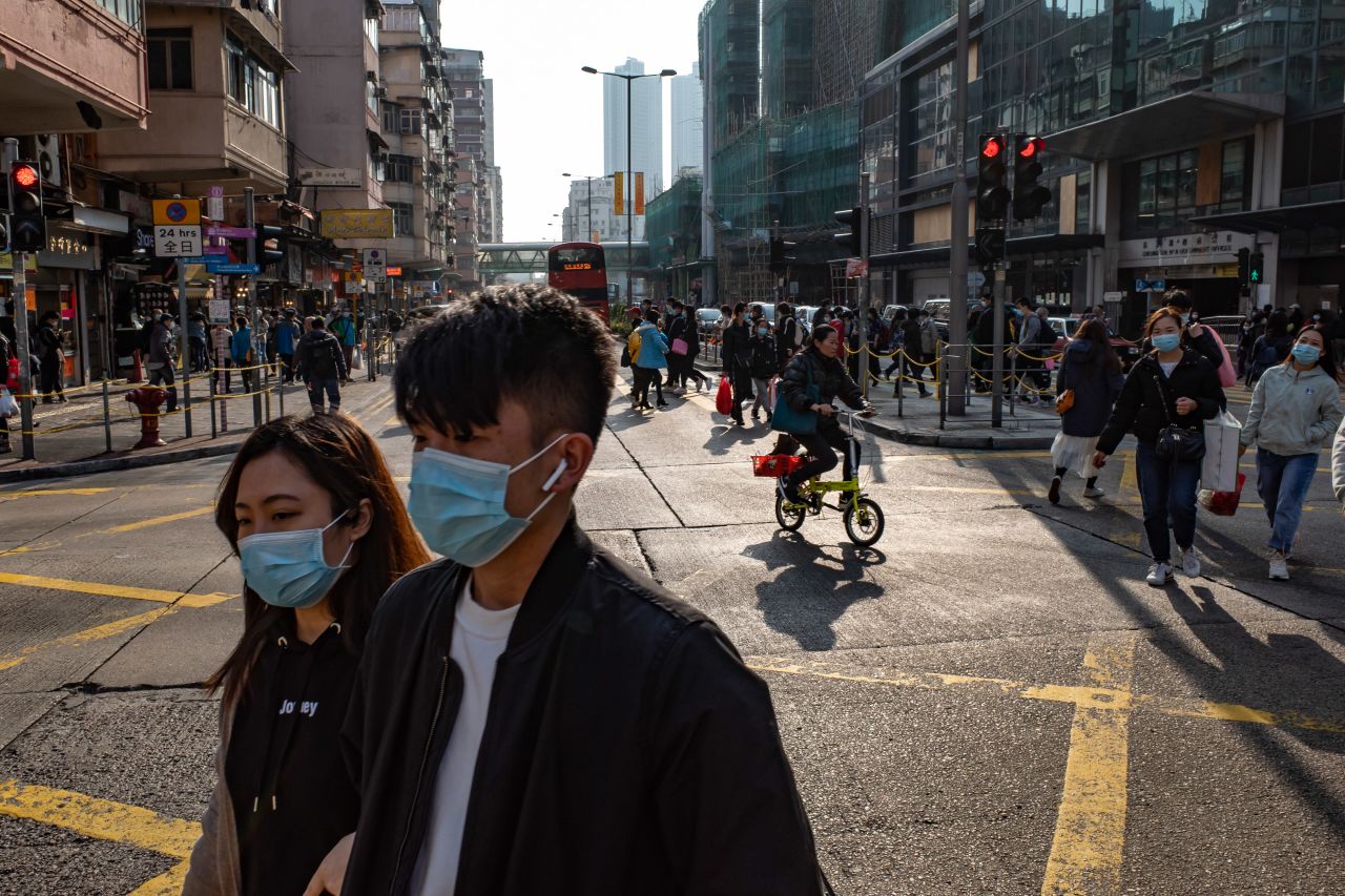 People wearing face masks cross an intersection at a shopping district on Saturday in Hong Kong.