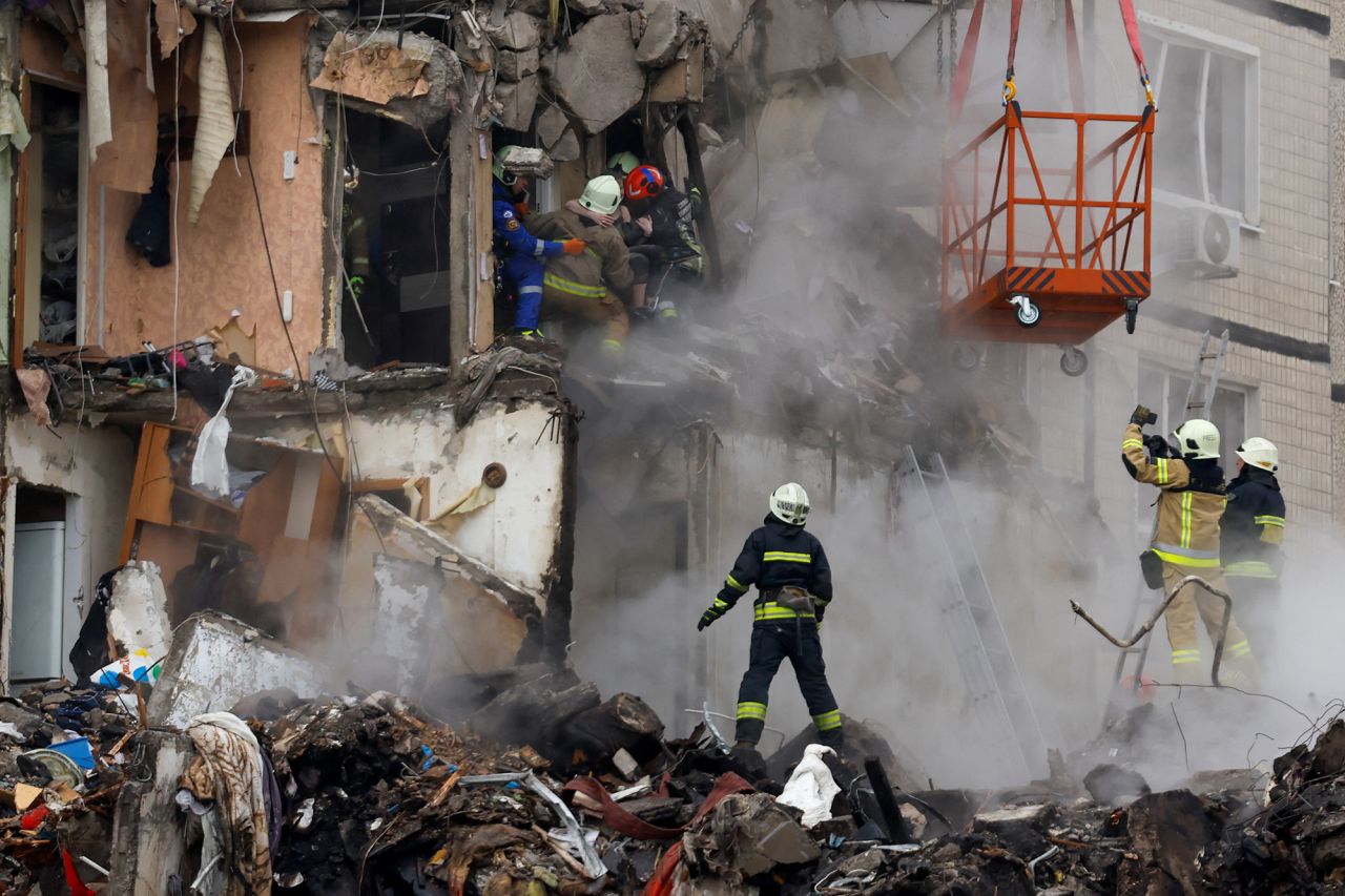 Emergency personnel evacuate a person at the site of the attack in Dnipro, Ukraine, on January 15.