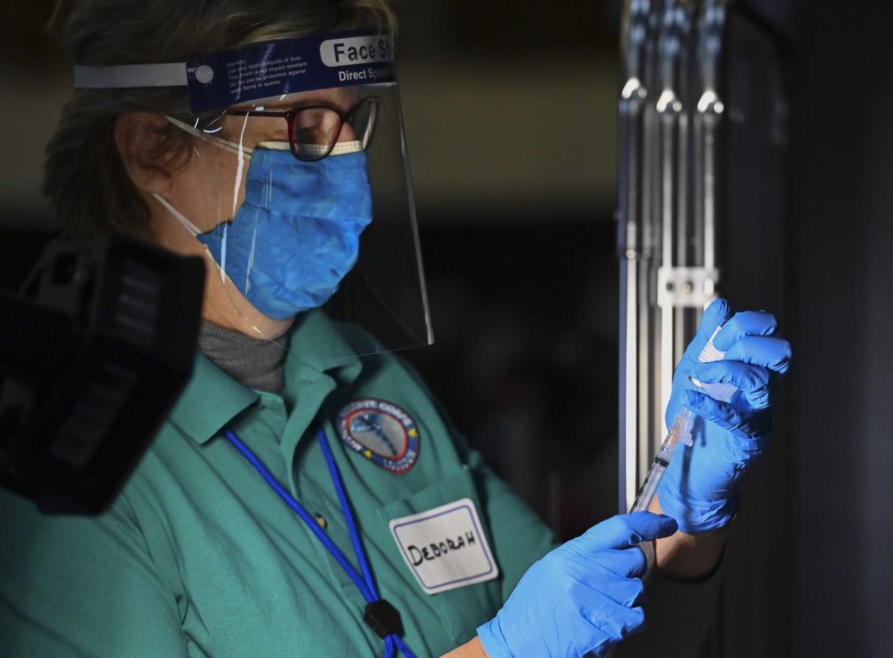 Nurse Deborah Henley fills a syringe with the Moderna Covid vaccine as first responders are vaccinated on December 28, in Sterling, Virginia.