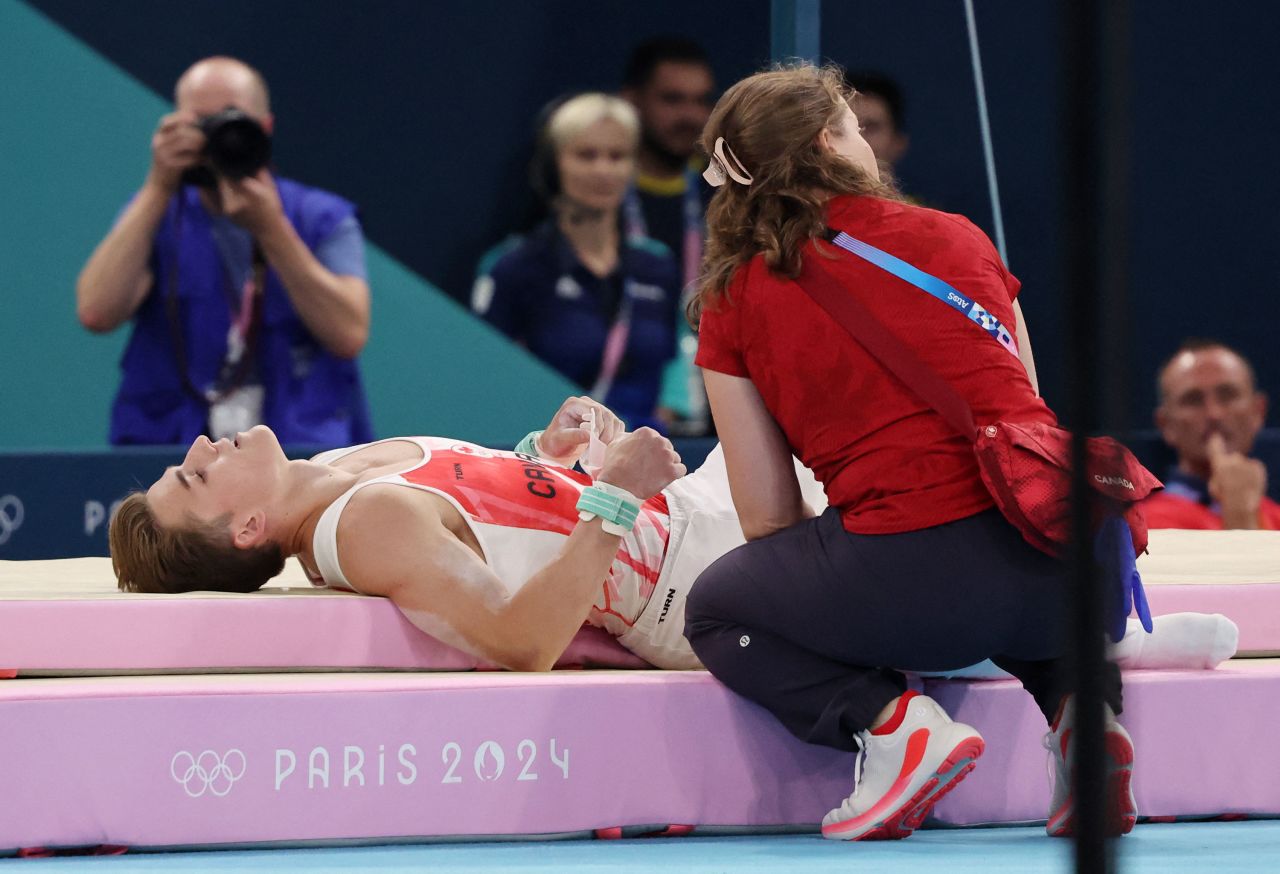 Felix Dolci of Canada receives medical attention after falling on the horizontal bar on Wednesday.