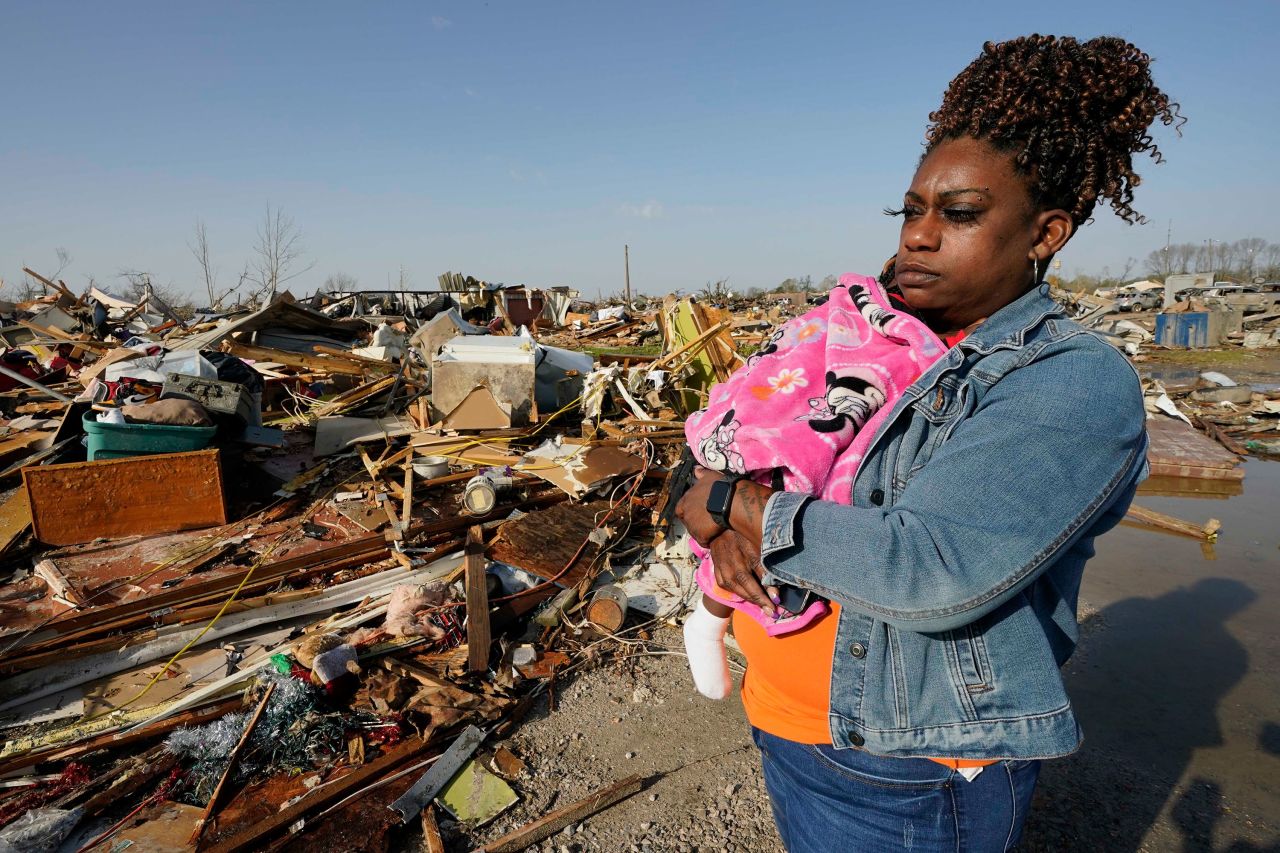 Wonder Bolden cradles her year-old granddaughter, Journey, as she surveys the remains of her mother's mobile home in Rolling Fork on Saturday. 