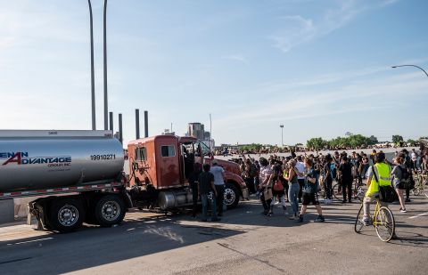 People react after a tanker truck drove into a crowd peacefully protesting the death of George Floyd on the I-35W bridge over the Mississippi River on May 31, in Minneapolis, Minnesota.